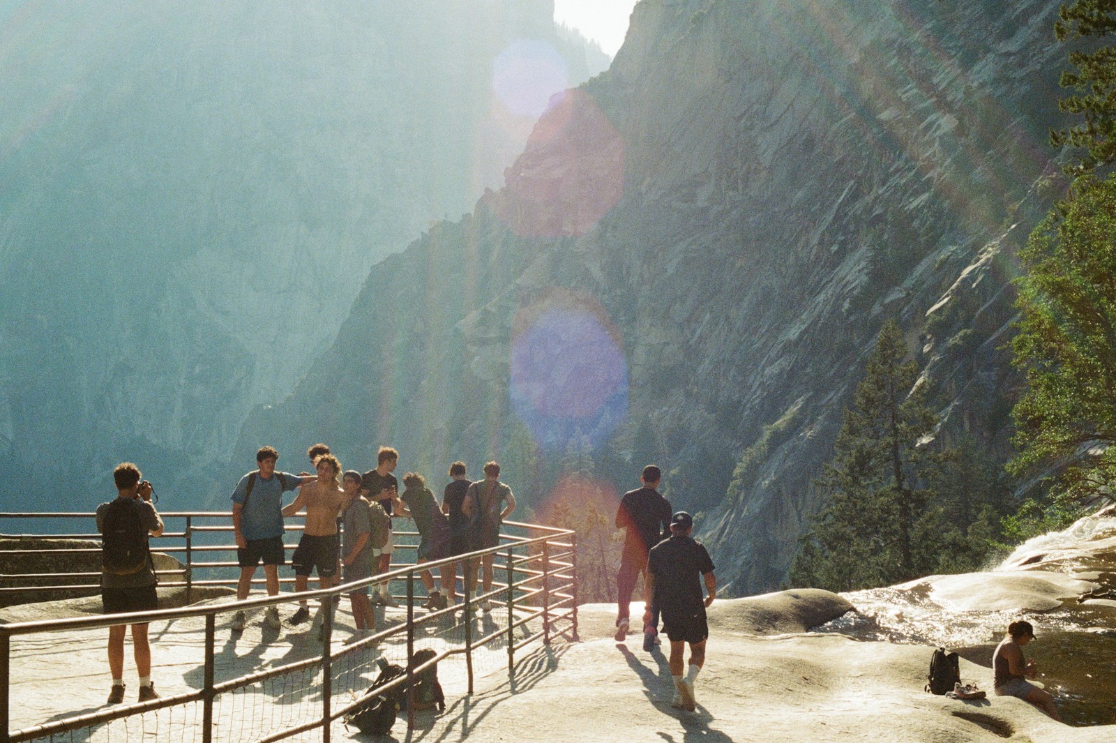 People gather on a scenic overlook with mountains